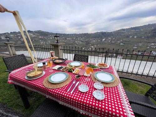 une table avec un tissu de table rouge et blanc et de la nourriture dans l'établissement Villa trabzon, à Çağlayan