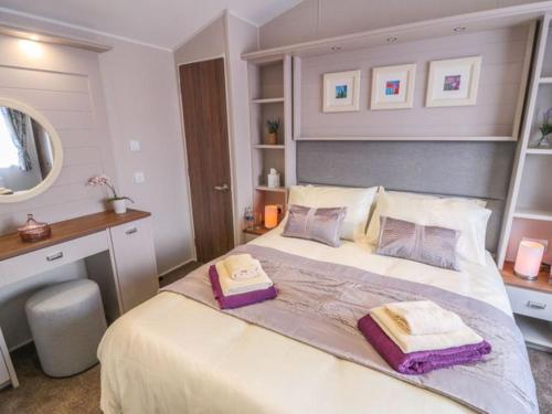 um quarto com uma cama grande com duas almofadas em Buttercup Lodge em Saltburn-by-the-Sea