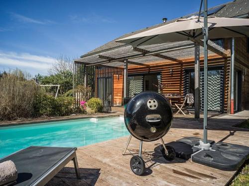 une maison avec une piscine et un parasol dans l'établissement Venez Chez Vous - Le Cocon du Parmelan, à Nâves-Parmelan