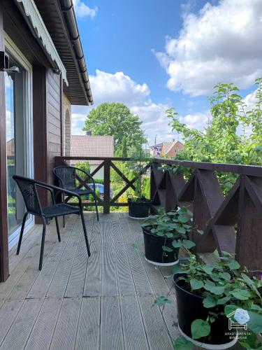 a porch with a bench and potted plants on it at Apartamentai Biržuose, double bedroom and single bedroom Apartments in Biržai