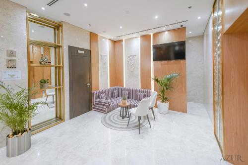 un hall d'entrée avec un canapé, une table et des chaises dans l'établissement Azur Regency Hotel Apartments, à Dubaï