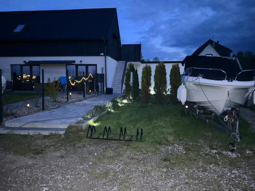 a boat parked on the grass in front of a house at Koniec Świata Stare Sady apartament in Mikołajki