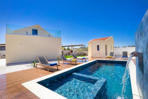 uma piscina com cadeiras e uma fonte de água em Villa Makisland With Sea View em Stavros