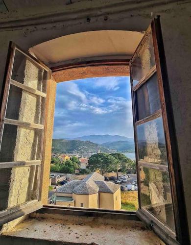 an open window with a view of a city at Villa Carletti à 3min des plages (7pers. - 3ch.) in Oletta