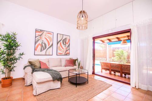 a living room with a couch and a table at Villa Tropical Private Pool Capellania By Holidays Home in La Oliva