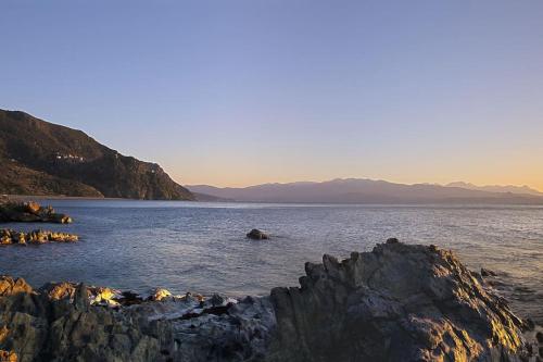 a large body of water with mountains in the background at Villa Carletti à 3min des plages (7pers. - 3ch.) in Oletta