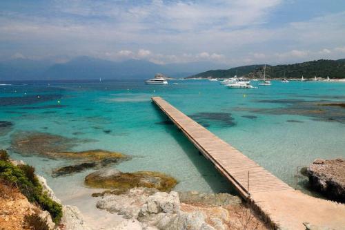a dock in the ocean with boats in the water at Villa Carletti à 3min des plages (7pers. - 3ch.) in Oletta