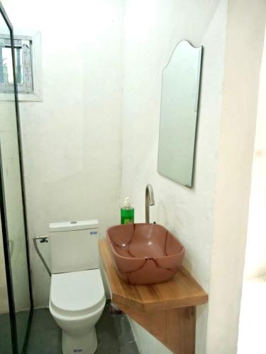 a bathroom with a bowl sink next to a toilet at Gêna house in Douala