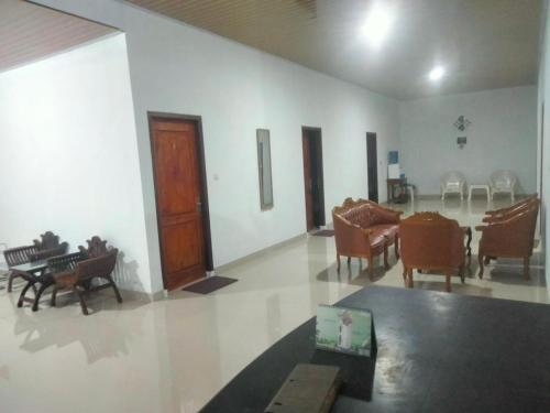 a living room with chairs and a table in it at Domen homestay syariah krui 64 in Krui