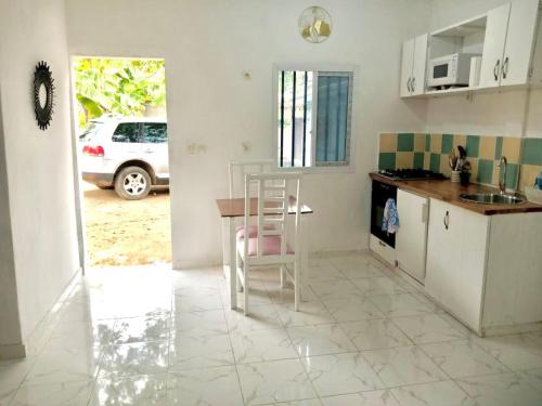 une cuisine avec une table et une chaise. dans l'établissement Gêna house, à Douala