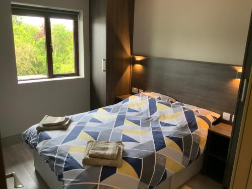 a bedroom with a colorful bed with two towels on it at Small,smart,tidy 2 bed apartment in Galway