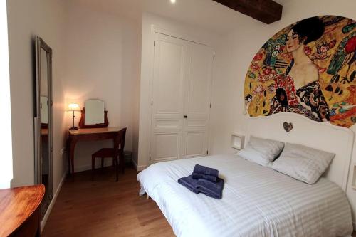 1 dormitorio con 1 cama blanca y una pintura en la pared en Classé 4 étoiles - Cybèle - Centre ville 2 Chambres, cour privative et Garage, en Vienne