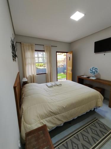 a bedroom with a large bed and a window at Pouso Casa da Vovó in Tiradentes