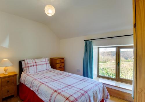 een slaapkamer met een bed en een raam bij Brynmeurig in Elerch