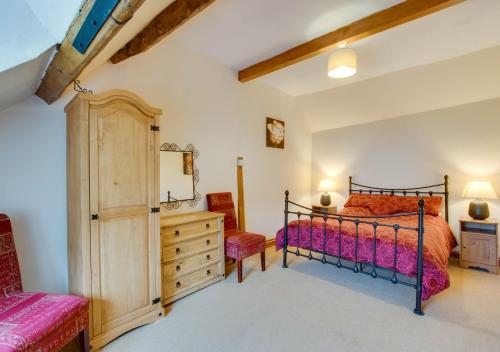 a bedroom with a bed and a dresser at Caer Mynach Cottage in Maesmynis