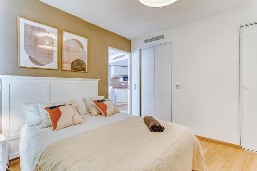 1 dormitorio con 1 cama blanca grande con almohadas en OVELIA Villeneuve-Loubet - Les Vagues de Vaugrenier, en Villeneuve-Loubet