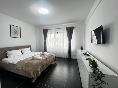 - une chambre avec un lit, une commode et une fenêtre dans l'établissement Luxury Cozy Apartments - City Center Suceava, à Suceava