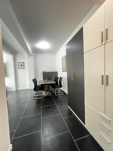 a dining room with a table and black tile floors at Cozy Aparthotel - Central City Suceava in Suceava