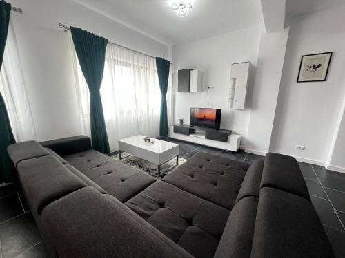 a living room with a couch and a tv at Cozy Aparthotel - Central City Suceava in Suceava