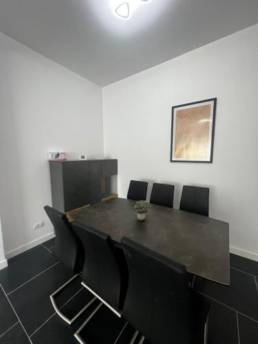 a dining room with a black table and chairs at Cozy Aparthotel - Central City Suceava in Suceava