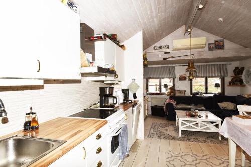 an open kitchen and living room with a couch at Nice independent holiday apartment on Saro in Särö