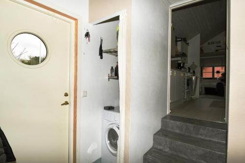 een wasruimte met een wasmachine naast een deur bij Nice independent holiday apartment on Saro in Särö