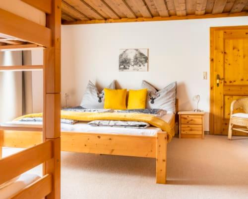 a bedroom with a wooden bed with yellow pillows at Unterwöhrlehen in Faistenau