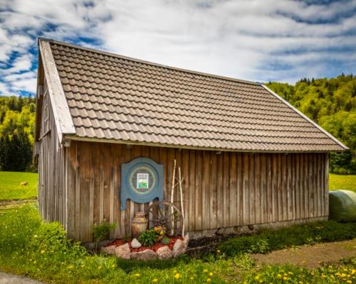 a small wooden building with a window in a field at Unterwöhrlehen in Faistenau
