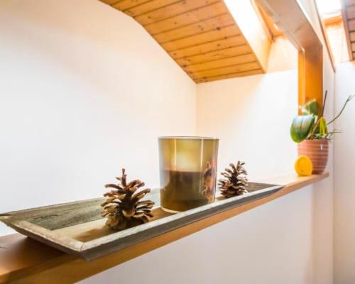 a shelf with a candle and pine cones on it at Unterwöhrlehen in Faistenau