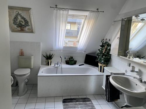 y baño con bañera, aseo y lavamanos. en Maison Beaumont, en Springe