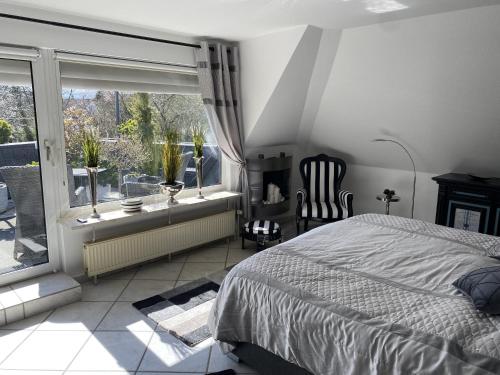 a bedroom with a bed and a large window at Maison Beaumont in Springe