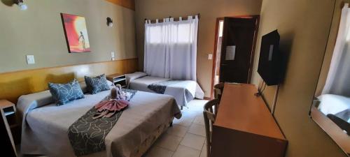 a hotel room with two beds and a television at Hotel Sebari in Villa Carlos Paz
