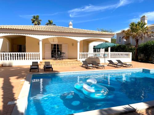a swimming pool with a toy in front of a house at Magellan House in Vilamoura