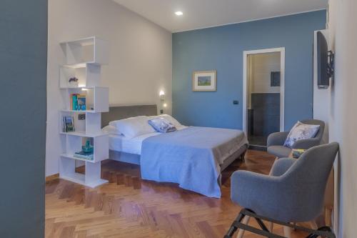 una camera con un letto e due sedie di Terrazza Mazzini Stylish by Wonderful Italy a Bellagio