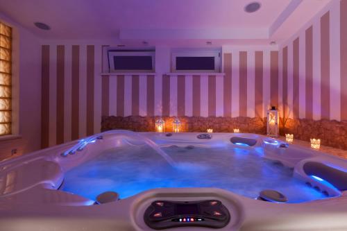 a jacuzzi tub in a room with purple lighting at Villa Puerto in Pobierowo