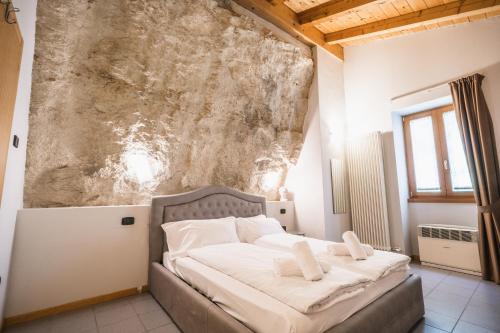 a bedroom with a bed in front of a wall at La Cantinota - Locanda De Manincor Rooms in Arco