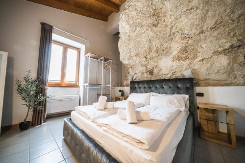 a bedroom with a large bed in a stone wall at La Cantinota - Locanda De Manincor Rooms in Arco