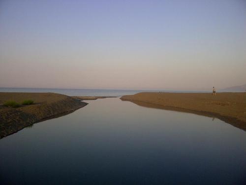 a person standing next to a body of water at The Villa Averoff in Kírinthos