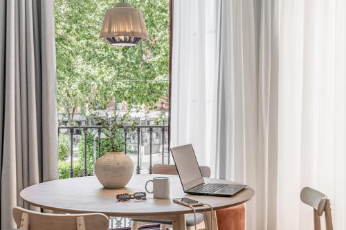 een tafel met een laptop in een kamer met een raam bij Líbere Ciudad Real in Ciudad Real