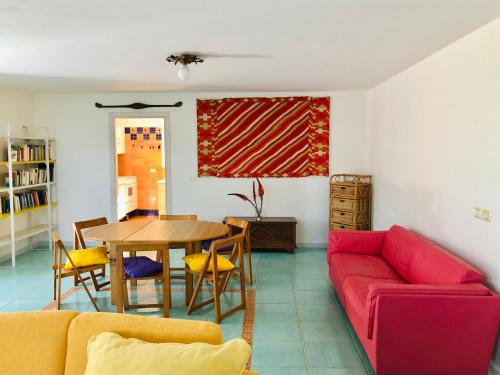 sala de estar con sofá rojo y mesa en Il Giardino di Elettra, en Palmadula