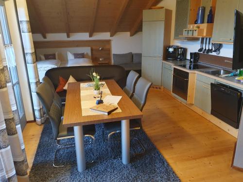 a kitchen with a wooden table and a dining room at Ferienhaus Tonihof in Langdorf im Landkreis Regen
