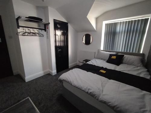 a bedroom with a large bed and a window at Black Ocean Holiday Apartments in Blackpool