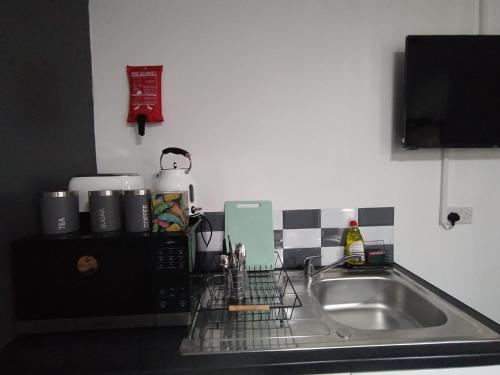 encimera de cocina con fregadero y microondas en Black Ocean Holiday Apartments, en Blackpool