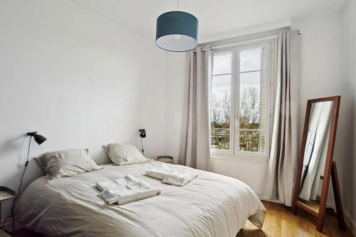 une chambre avec un lit blanc avec des serviettes dessus dans l'établissement Sublime Appart Tout Confort Centre Ville Gare, à Troyes