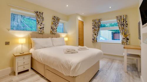 a bedroom with a bed and two windows at Langland Corner Lodge in Newton