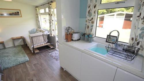 a kitchen with white cabinets and a window at Pebbles Summercliffe Park in Newton