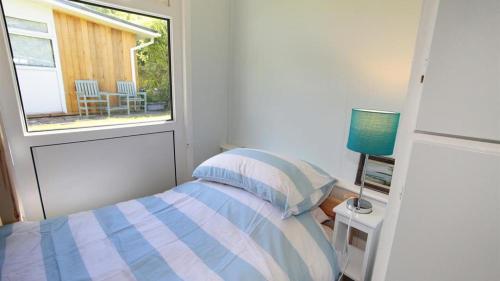 a small bedroom with a bed and a window at Pebbles Summercliffe Park in Newton