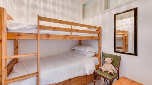 a bedroom with two bunk beds and a teddy bear at Redcliffe Apartments E in Bishopston