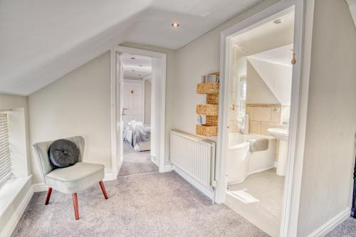 a white bathroom with a chair and a tub at Pass the Keys Cosy Hideaway in the Countryside in Lincoln
