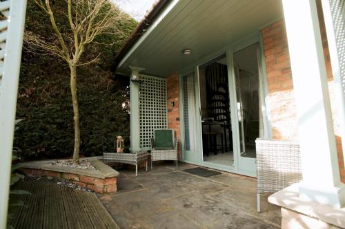 a porch of a house with a tree on it at Pass the Keys Cosy Hideaway in the Countryside in Lincoln